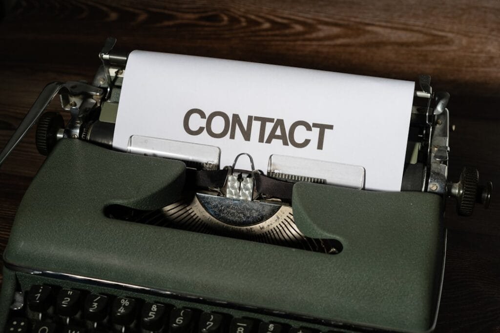 Vintage typewriter with "CONTACT" paper representing professional follow-up communication and business outreach