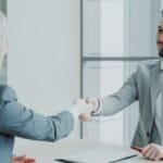 Professional job interview handshake between HR manager and candidate in modern office - Photo by Unsplash