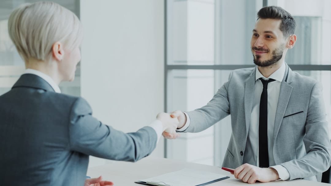 Professional job interview handshake between HR manager and candidate in modern office - Photo by Unsplash